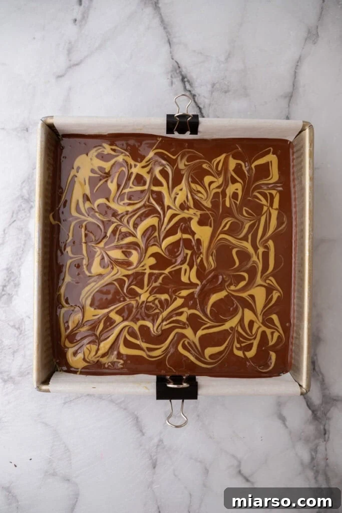 Dubai's Viral Pistachio Kunafa Brownies 20 a finished dubai chocolate brownie in the pan showing swirls of chocolate and pistachio spread