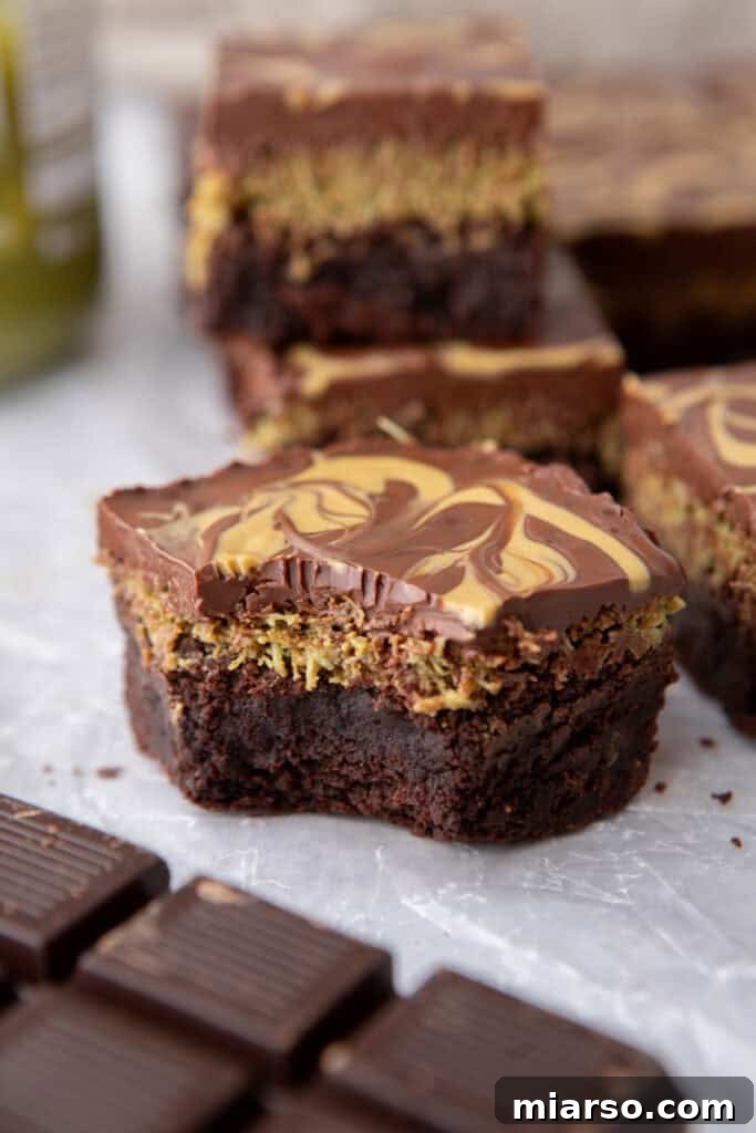 Dubai's Viral Pistachio Kunafa Brownies 4 Dubai Chocolate Brownies Recipe with a bite taken out, showing distinct layers