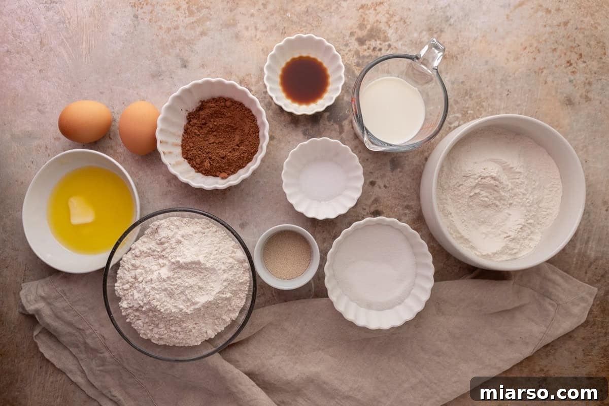 Ingredients for chocolate cinnamon roll dough including flour, cocoa powder, eggs, milk, and yeast