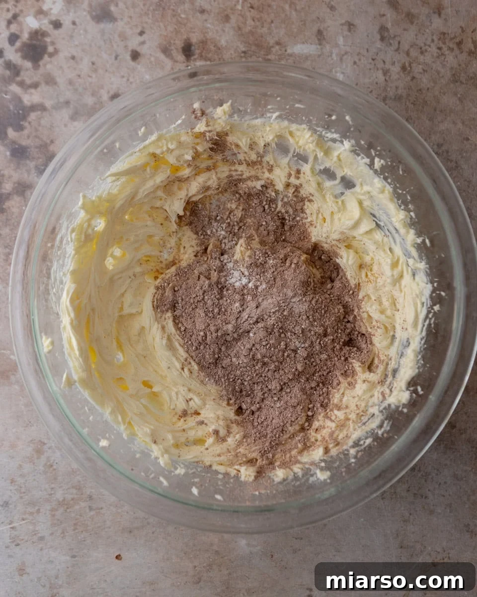Chocolate cream cheese frosting being mixed in a bowl