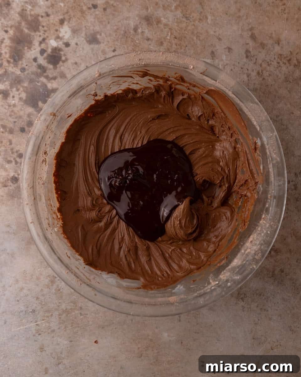 Melted chocolate added to chocolate cream cheese frosting