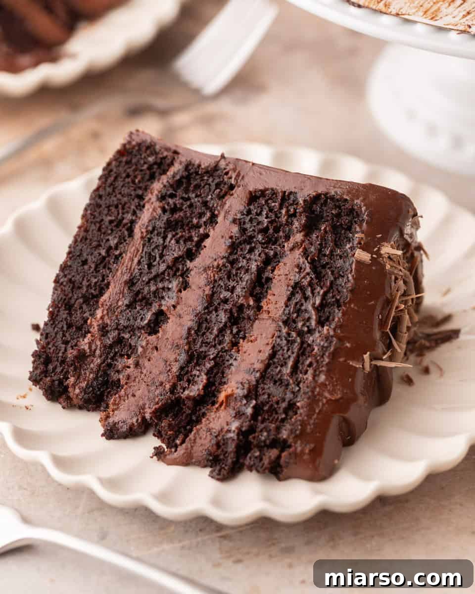 Slice of rich fudgy layer cake with chocolate frosting and a fudgy crumb