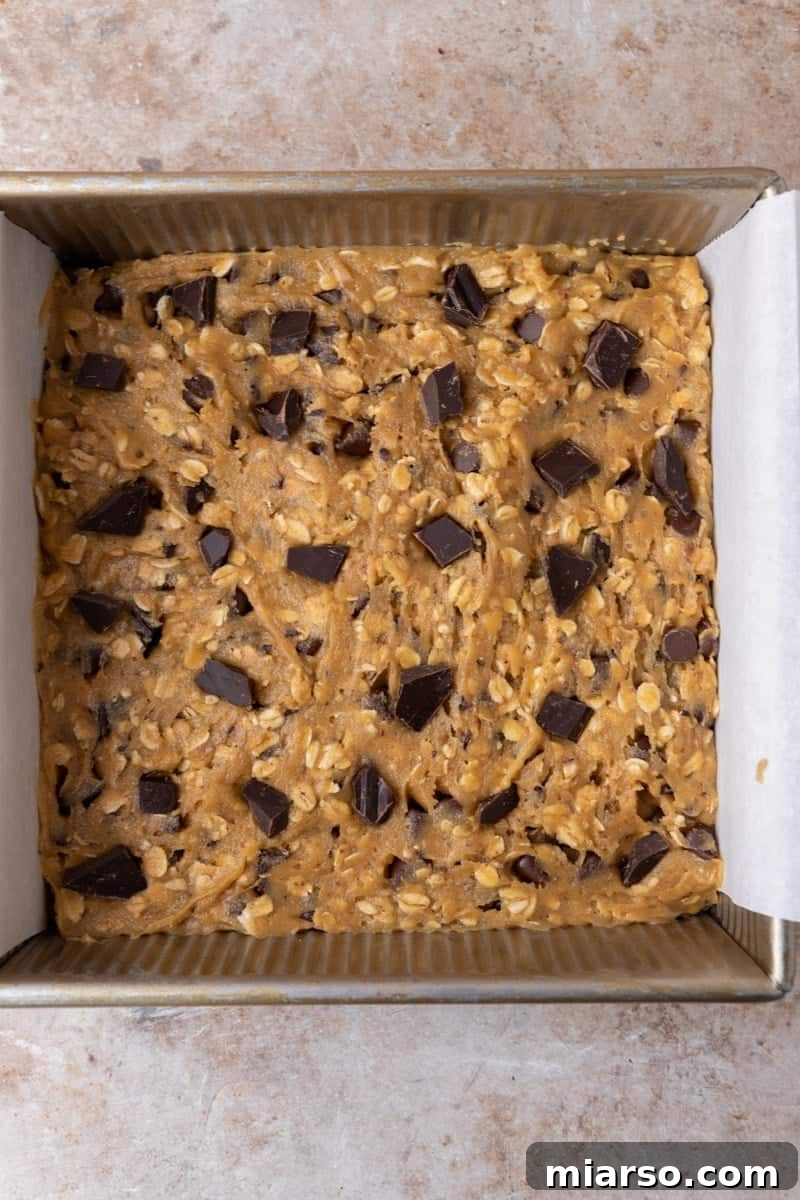 Close up of sliced chewy cookie bars with one tilted to show the gooey chocolate center and soft interior
