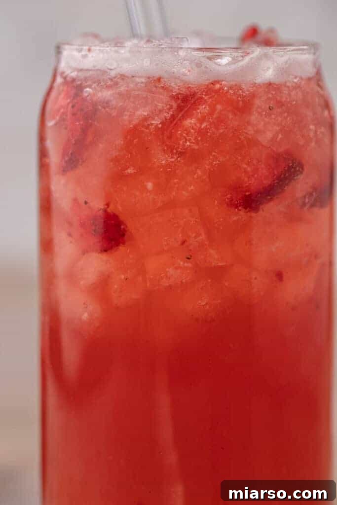 Starbucks copycat strawberry acai refresher with freeze dried strawberries and ice in a glass
