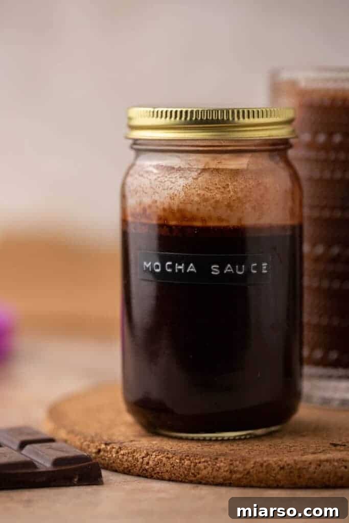 Homemade Starbucks mocha sauce stored in a glass jar with a gold lid for Starbucks copycat recipes