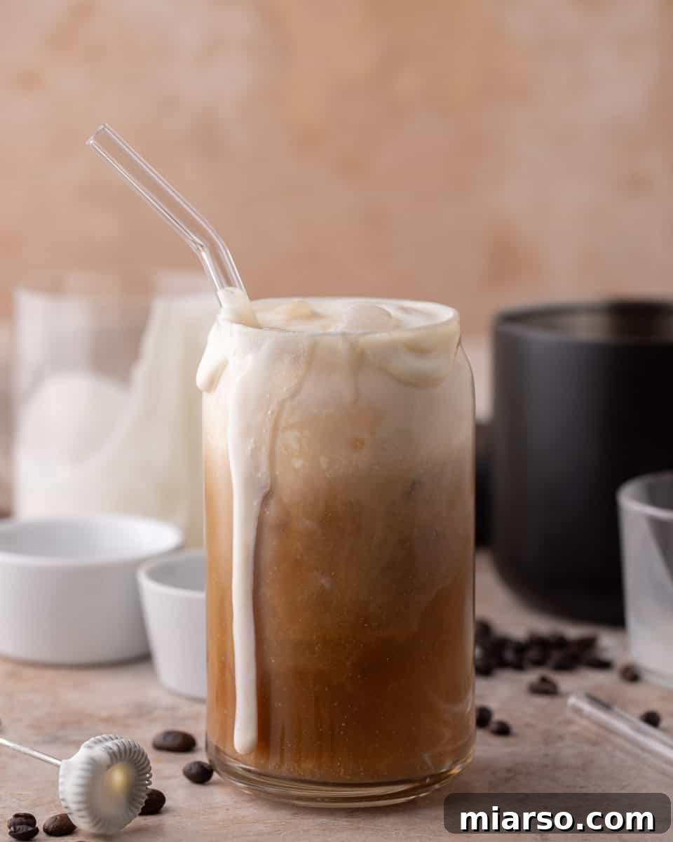 Thick vanilla sweet cream cold foam overflowing on top of a homemade Starbucks iced cold brew