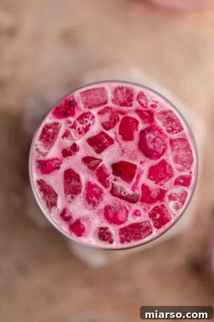 Overhead view of a homemade Starbucks pink drink with freeze dried dragonfruit pieces and coconut milk