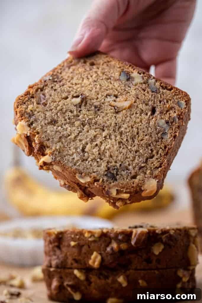 Moist Starbucks copycat banana bread slice with walnuts showing dense bakery-style crumb