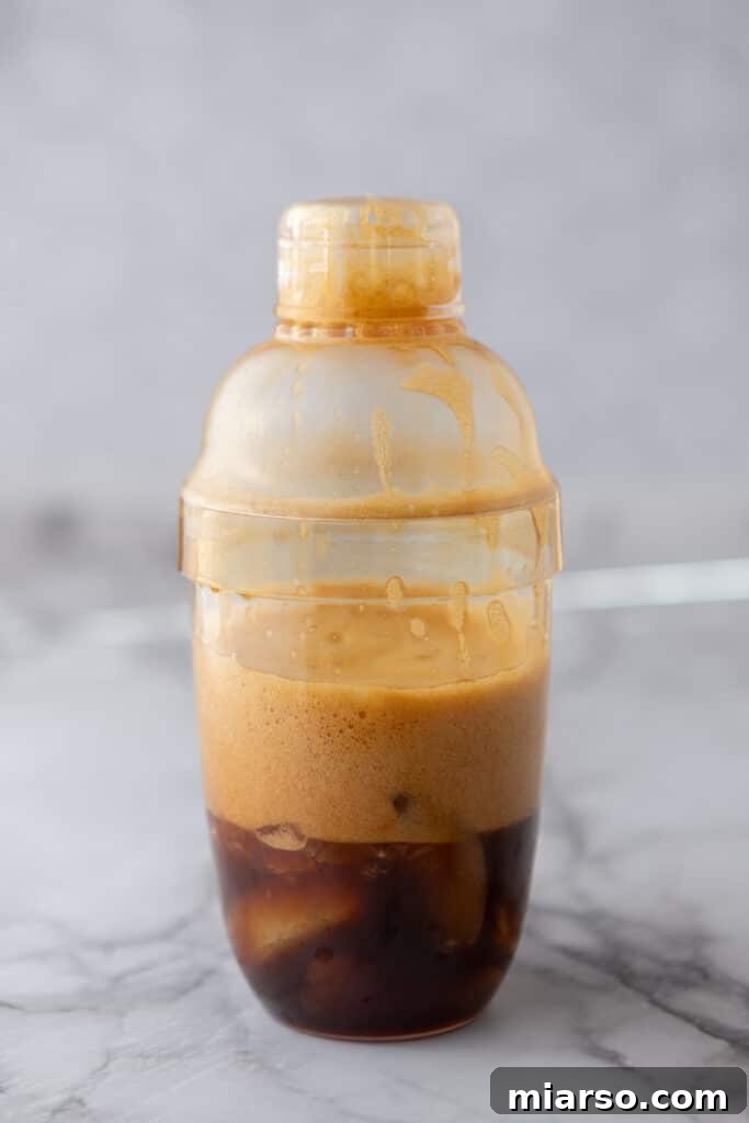 Frothy brown sugar oatmilk shaken espresso after shaking in a cocktail shaker for this Starbucks copycat recipe
