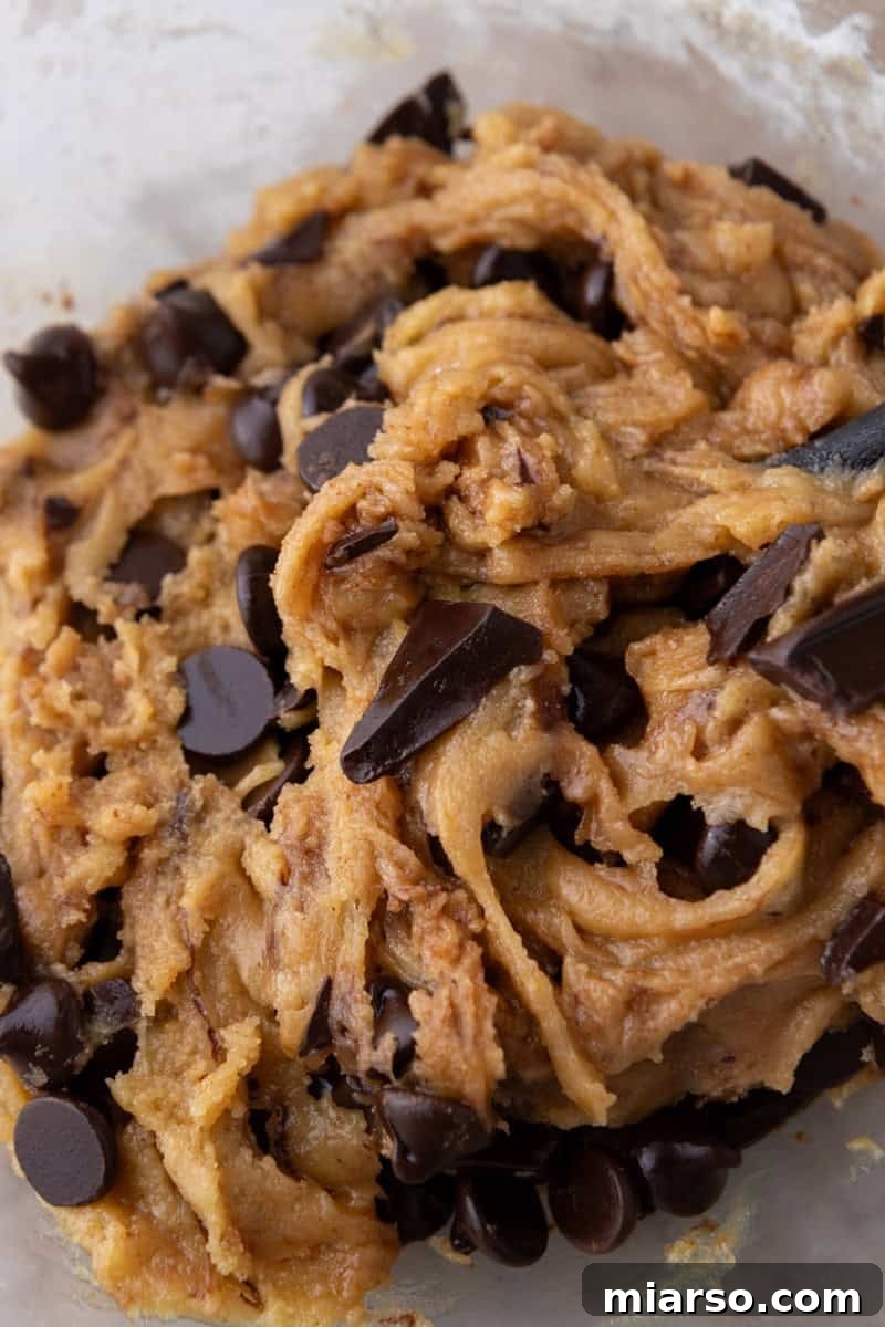 Nutty Brown Butter Chocolate Chip Skillet Cookie 10 Close-up of thick cookie dough showing the rich golden color from brown butter and a mix of chocolate chips and chopped dark chocolate