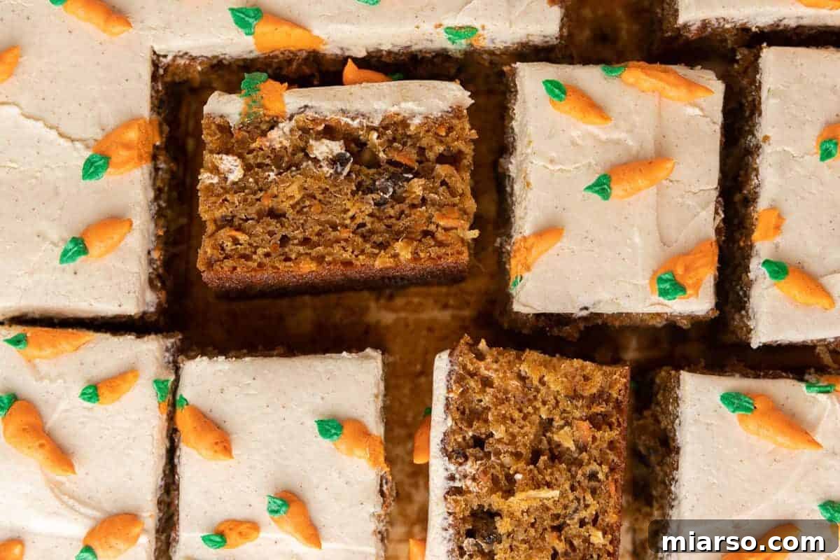 Effortless Easter Treats for Spring Gatherings 5 A moist carrot cake sheet cake, cut into squares, with cream cheese frosting and piped carrot decorations in a 9x13 pan.