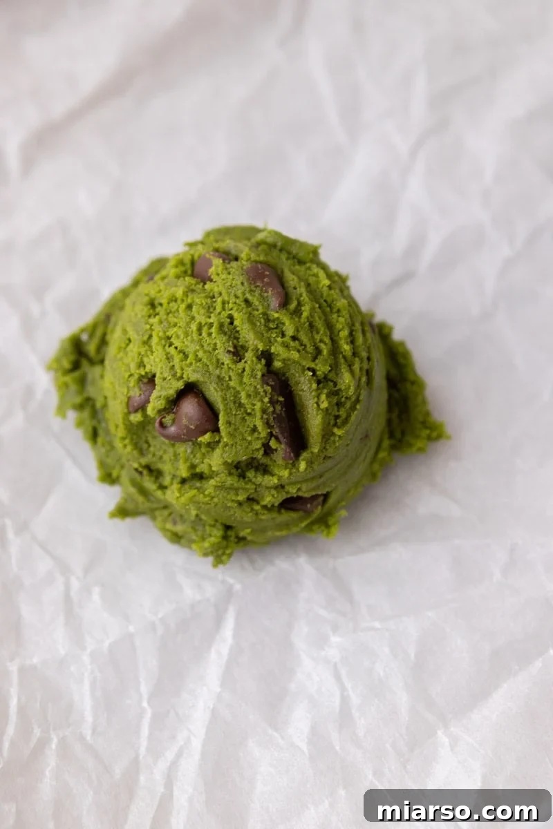 Velvet Matcha Chocolate Chip Cookies 11 Finished matcha cookie dough with chocolate chips mixed throughout in a glass bowl
