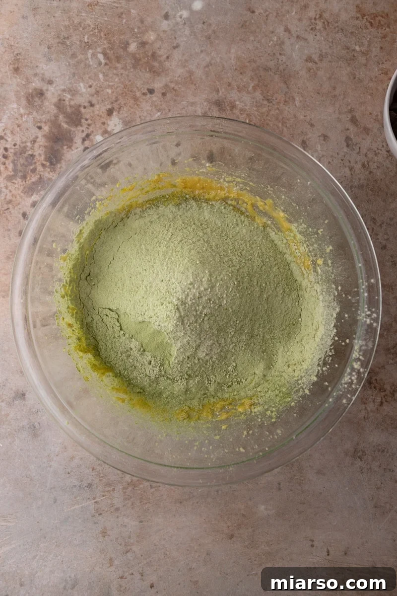 Velvet Matcha Chocolate Chip Cookies 8 Matcha flour mixture added to the wet ingredients in a glass mixing bowl before combining
