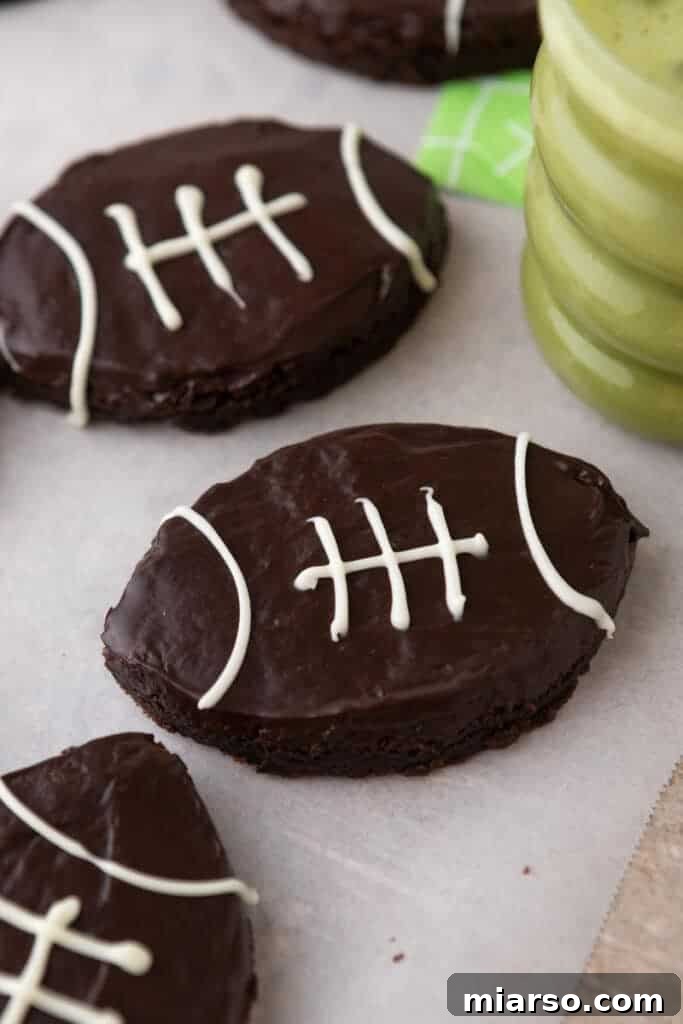 Football-shaped brownies presented next to a decorative cup, perfect for game day celebrations.