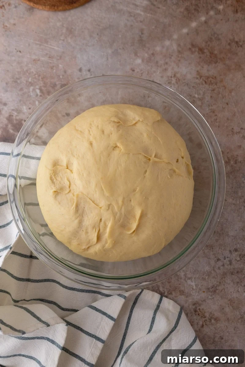 Doubled lemon brioche dough in a glass bowl after first rise