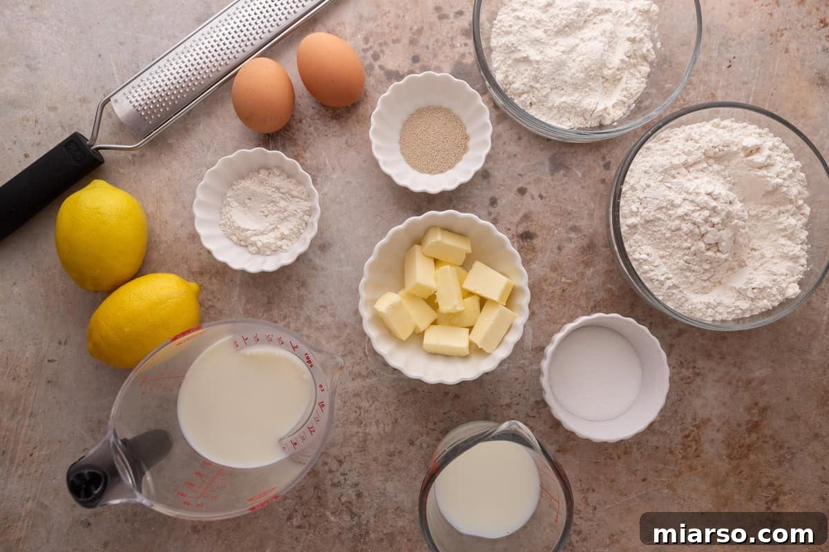 Flatlay of dough ingredients including eggs, yeast, flour, butter, milk and lemons