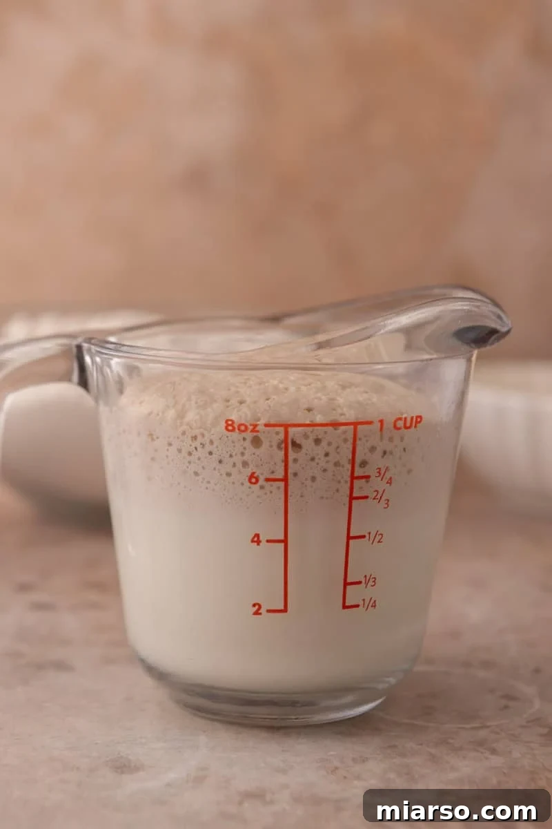 Foamy proofed yeast in a glass measuring cup showing active yeast