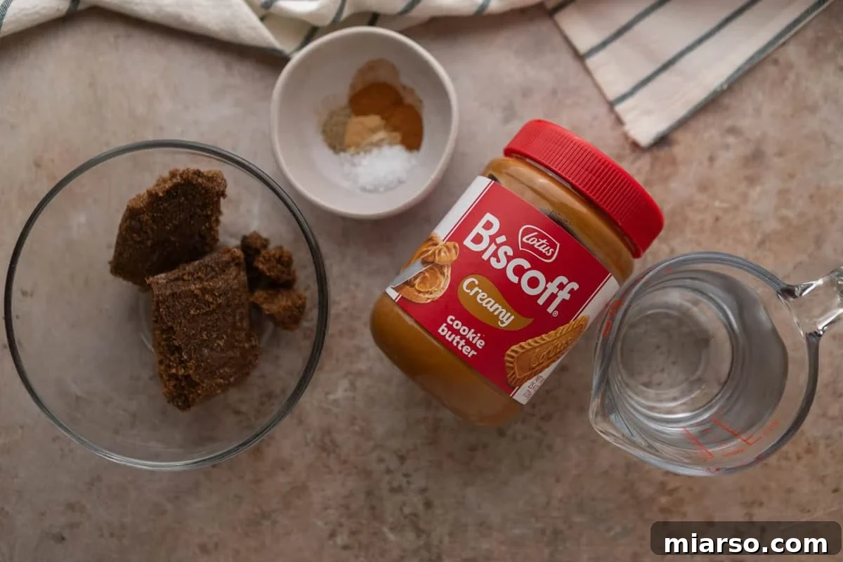 Biscoff Cookie Butter Latte Syrup 3 Ingredients for cookie butter coffee syrup including Lotus Biscoff spread, dark brown sugar, spices, and water measured out in bowls.
