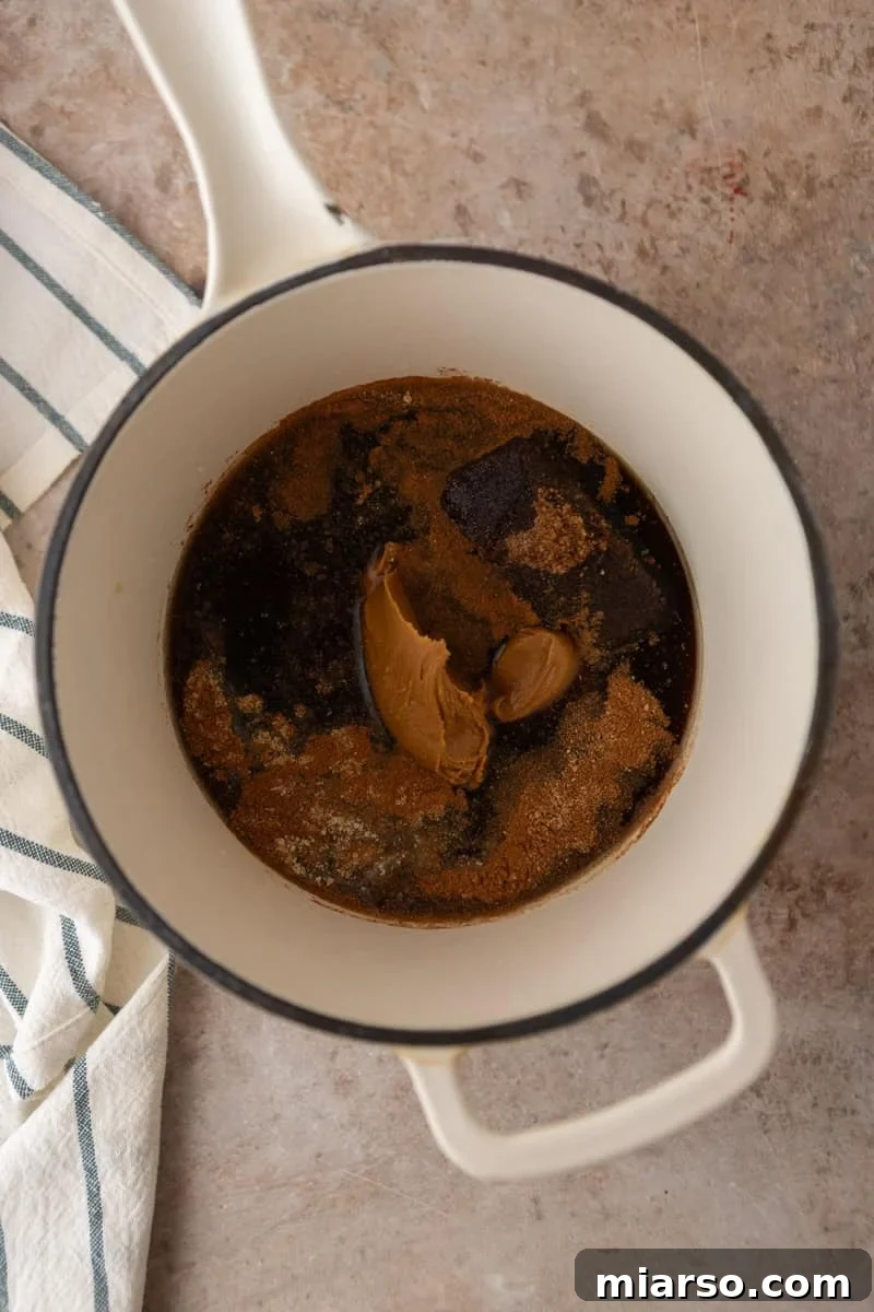 Biscoff Cookie Butter Latte Syrup 4 Dark brown sugar, Biscoff cookie butter, and spices added to a saucepan before cooking.