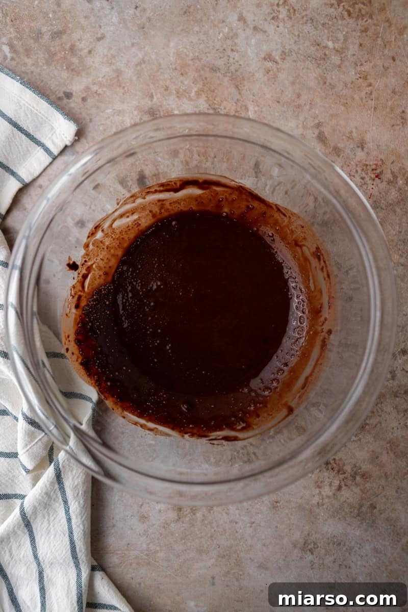 Ultimate Moist Marble Layer Cake with Rich Chocolate Cream Cheese Frosting 8 Dutch-process cocoa powder bloomed in hot coffee to make a smooth chocolate paste in a glass bowl