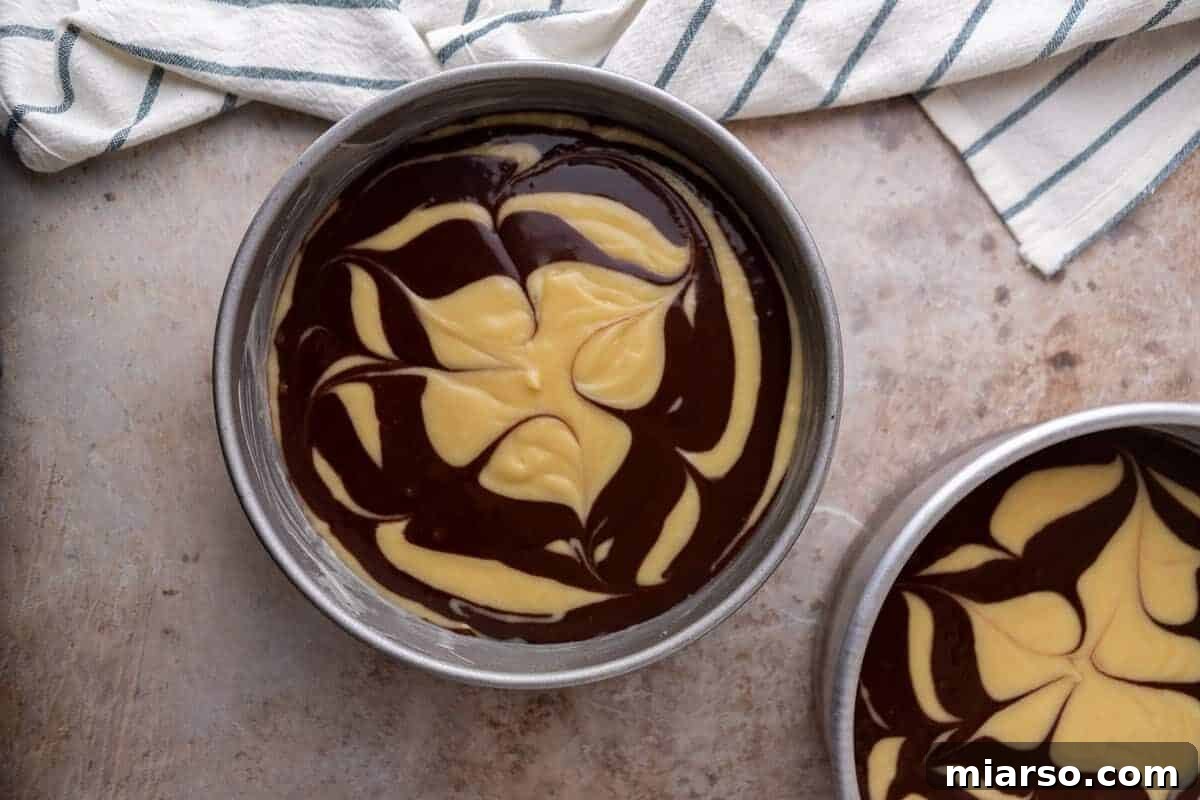 Ultimate Moist Marble Layer Cake with Rich Chocolate Cream Cheese Frosting 10 Vanilla and chocolate cake batter swirled together in two round cake pans before baking