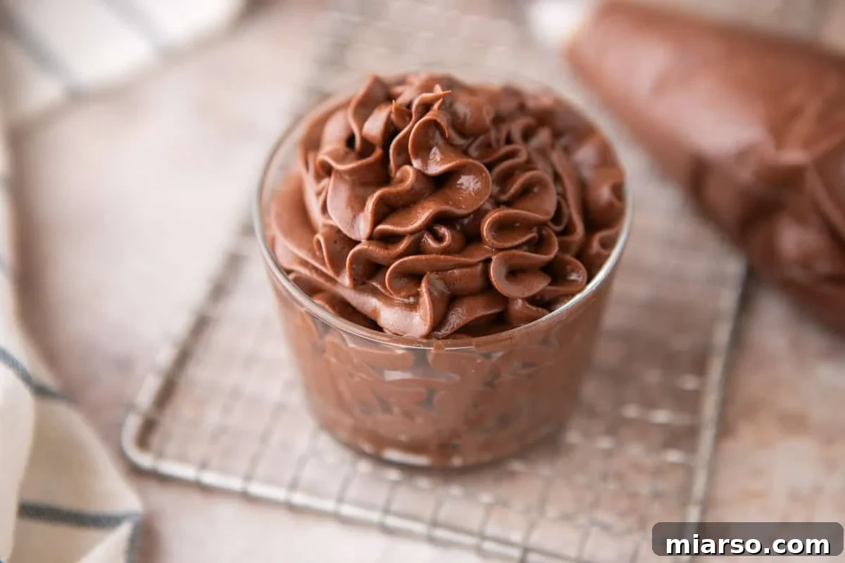 Velvety Chocolate Cream Cheese Indulgence 2 Chocolate cream cheese frosting piped into a small glass jar on a wire cooling rack