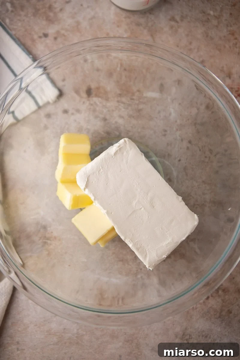 Velvety Chocolate Cream Cheese Indulgence 4 Block of cream cheese and cubes of softened butter in a glass mixing bowl