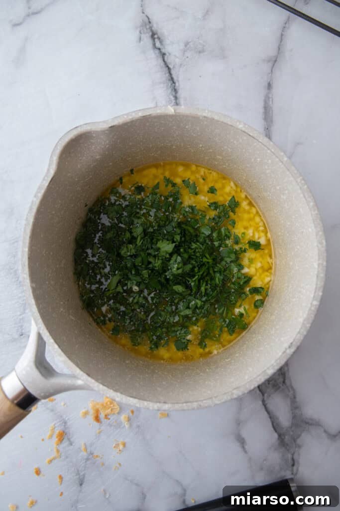 Melted garlic butter with chopped parsley in saucepan
