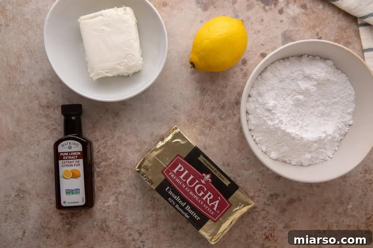 Cream cheese lemon frosting ingredients flatlay with Plugrà butter, cream cheese, powdered sugar, lemon, and lemon extract.