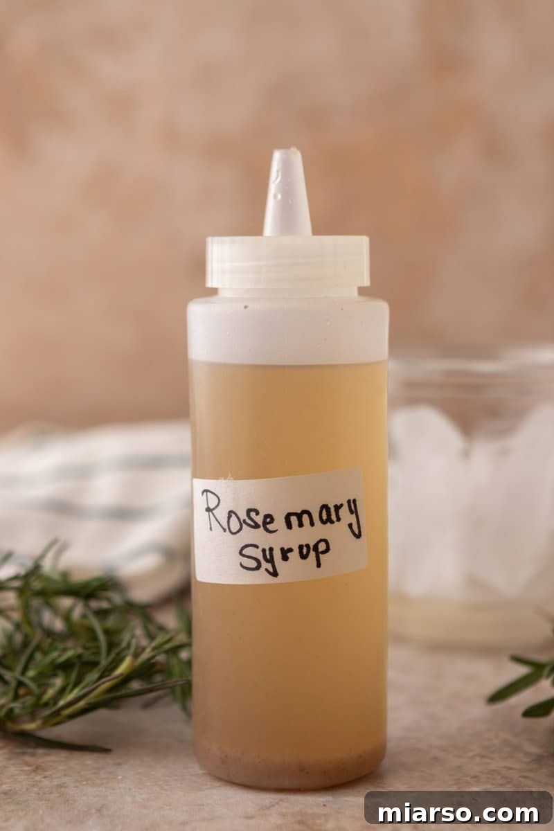 Homemade rosemary syrup in a squeeze bottle with a handwritten label