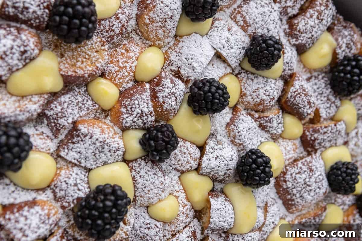 Easy Mother's Day brunch recipe with pretzel French toast bake topped with lemon curd, fresh blackberries, and powdered sugar