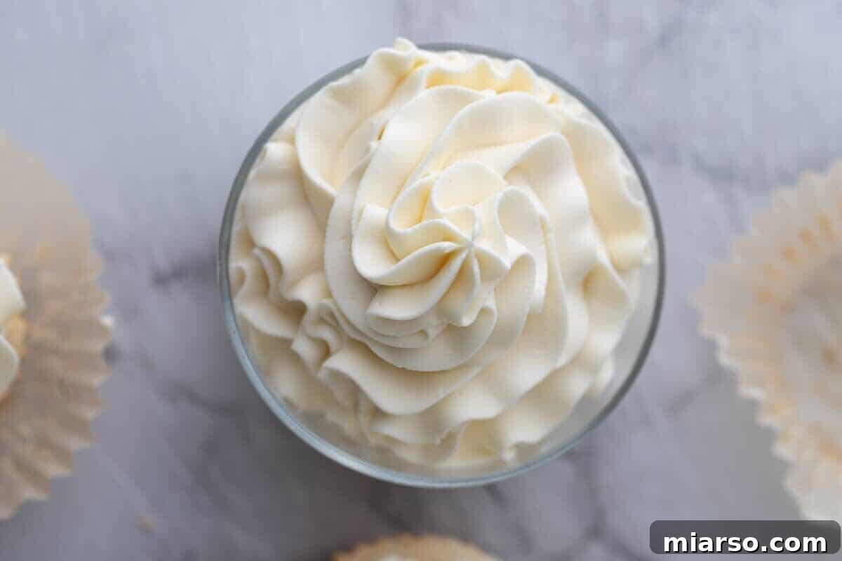 Light and airy mascarpone frosting piped into a glass bowl, perfect for topping Mother's Day cakes and cupcakes