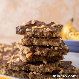 Stack of banana bread Christmas crack pieces on a plate with a banana in the background.