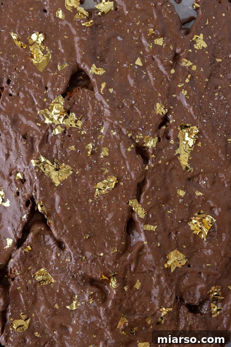 Croissant Christmas crack topped with melted chocolate, flaky salt, and edible gold leaf