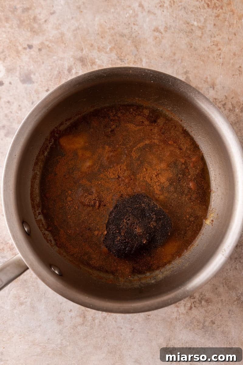 Banana bread syrup mixture simmering in a saucepan with dark brown sugar and cinnamon