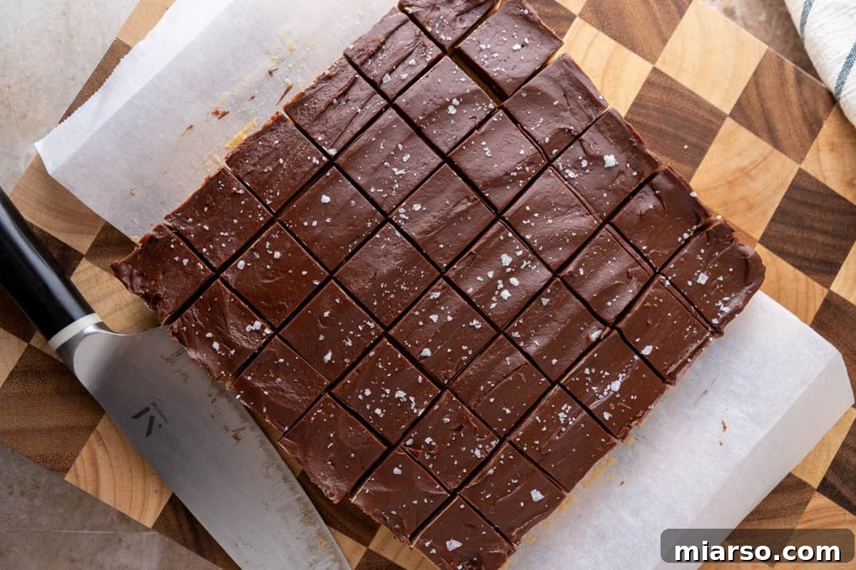 Buckeye fudge cut into squares on a cutting board topped with flaky salt