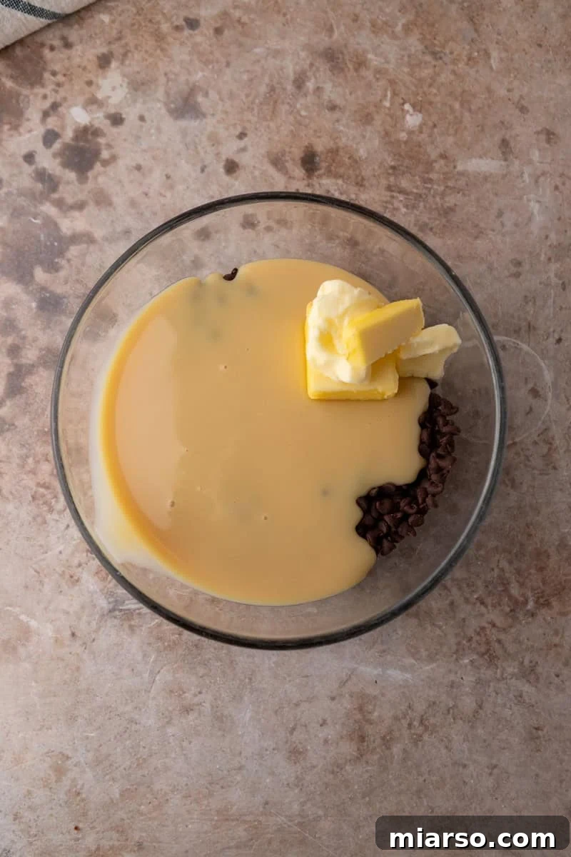 Chocolate chips, sweetened condensed milk, and butter in a glass bowl before melting