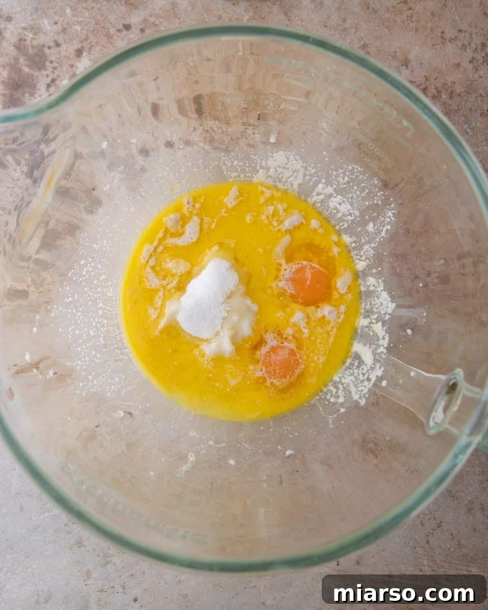 Melted butter, eggs, sugar and salt combined in a glass bowl to start the brioche dough