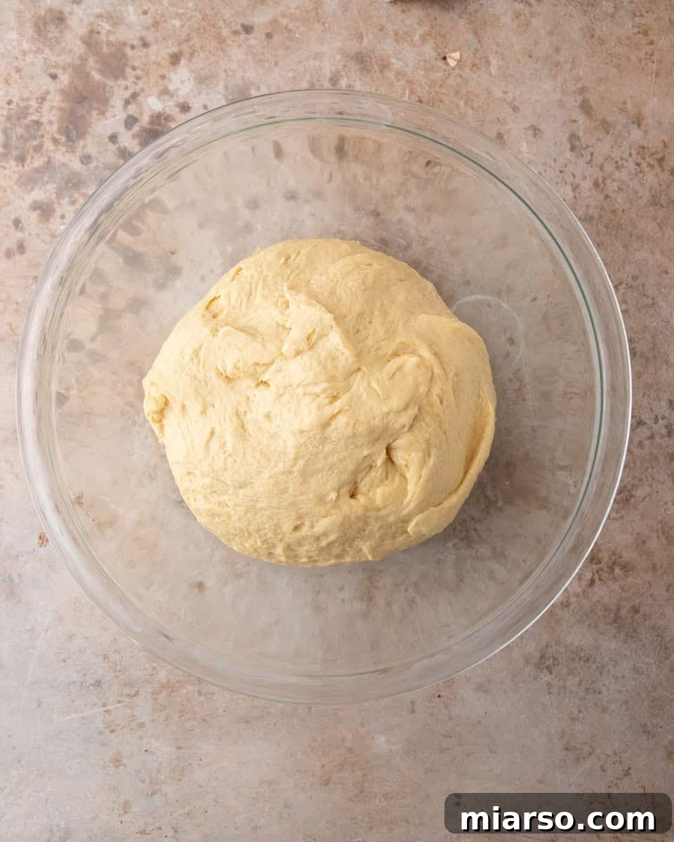 Smooth ball of tangzhong brioche dough in a glass bowl before the first rise