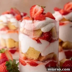 Mini Strawberry Shortcake Trifle Cups Recipe 12 Strawberry shortcake cups showing distinct layers of cake, whipped cream, and sweet macerated strawberries.