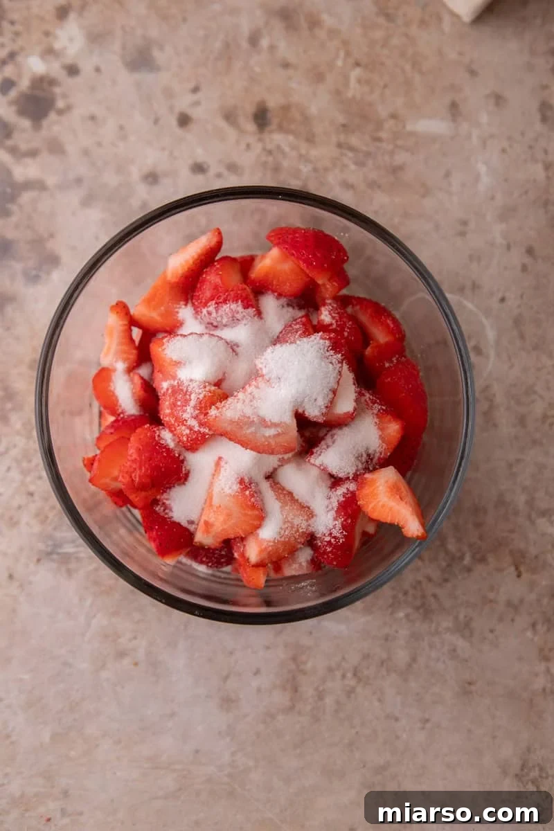 Mini Strawberry Shortcake Trifle Cups Recipe 7 Diced fresh strawberries tossed with granulated sugar in a glass bowl.