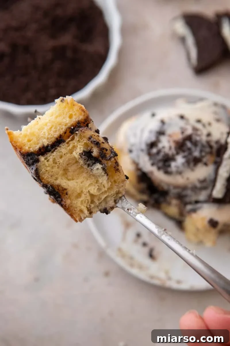 Oreo-Stuffed Cinnamon Rolls with Cream Cheese Glaze 13 Forkful of Oreo cinnamon roll showing the soft interior and Oreo filling swirl