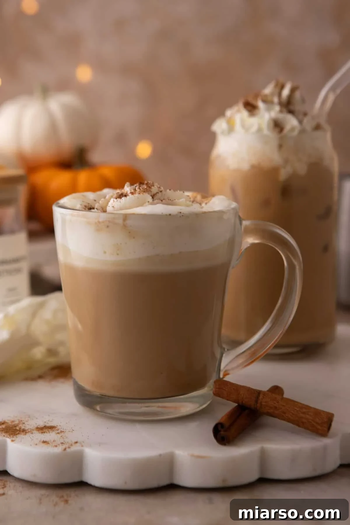 Make a Copycat Starbucks Pumpkin Spice Latte at Home 2 Copycat Starbucks pumpkin spice latte in a glass mug with whipped cream and spice dusting.