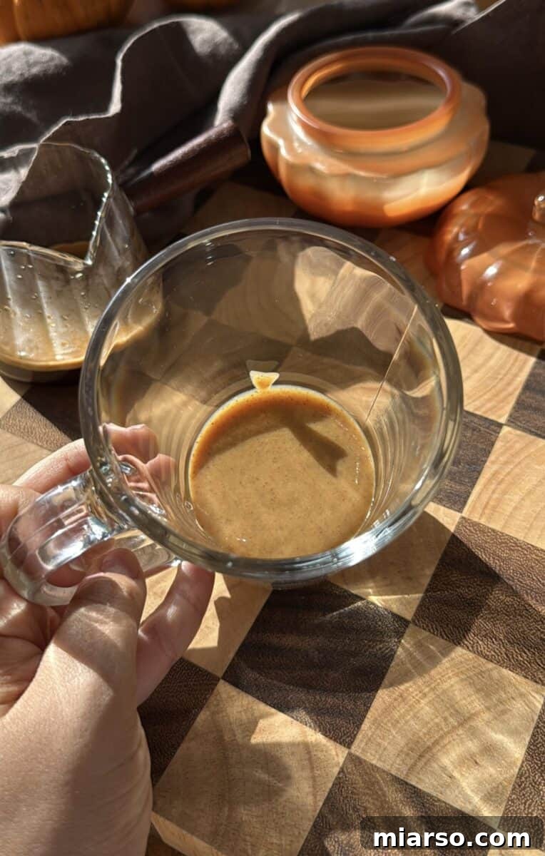 Make a Copycat Starbucks Pumpkin Spice Latte at Home 4 Pumpkin spice sauce in a tall glass mug.