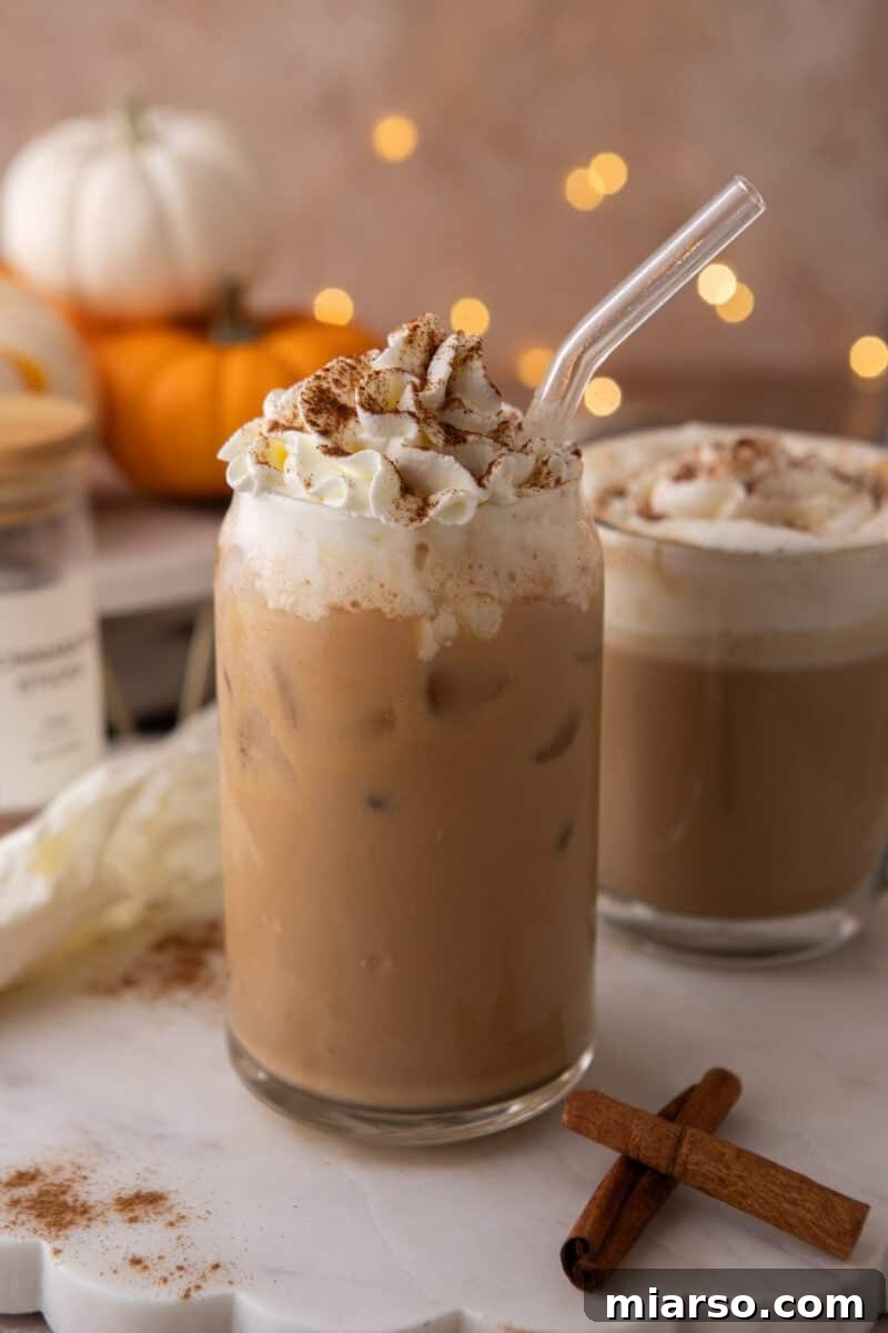 Make a Copycat Starbucks Pumpkin Spice Latte at Home 8 Iced pumpkin spice latte in a tall glass with cold milk poured over ice cubes.